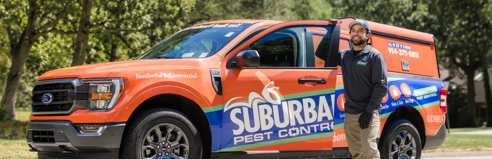 technician standing next to company truck smiling